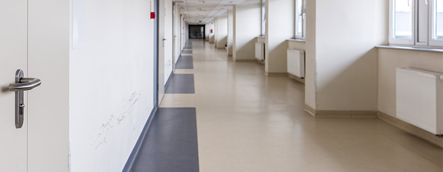 A hospital hallway with scuff marks and wall damage on the walls
